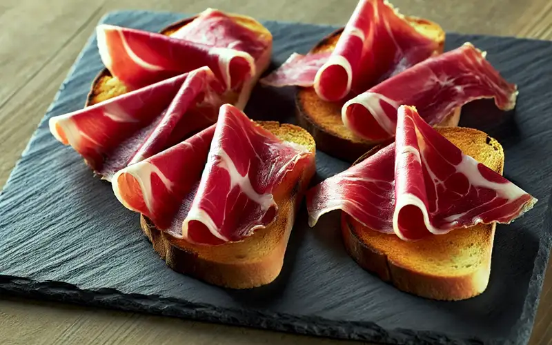 Jamón ibérico con pan y tomate.